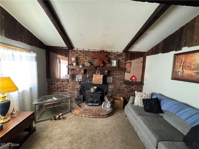 living room with lofted ceiling with beams, carpet, and a wood stove