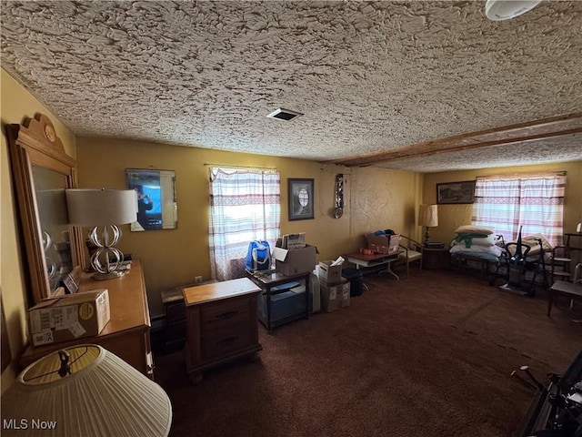 misc room featuring dark carpet and a textured ceiling