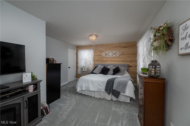 carpeted bedroom featuring wood walls