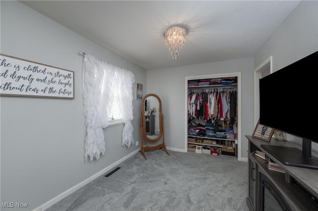 bedroom with light colored carpet, a closet, and a chandelier