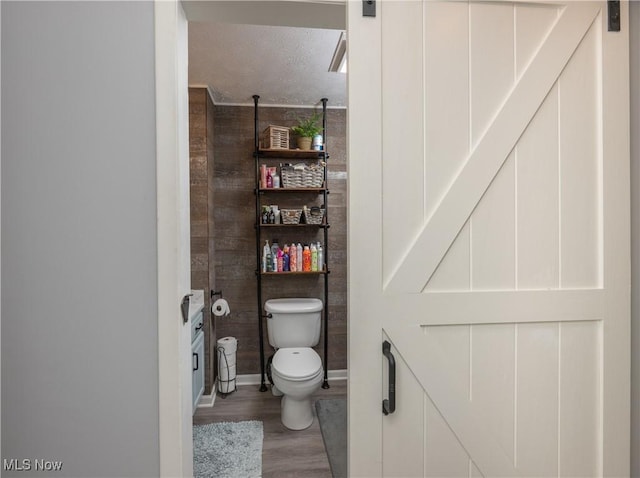 bathroom featuring hardwood / wood-style floors, a textured ceiling, and toilet