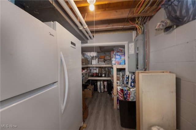 basement with wood-type flooring and white fridge