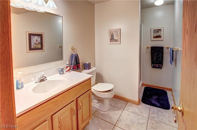 bathroom with vanity, a shower with shower door, tile patterned floors, and toilet