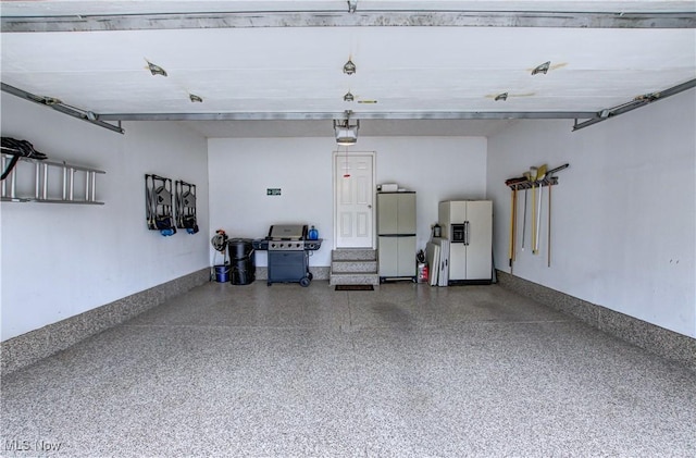 garage with white refrigerator, a garage door opener, and white refrigerator with ice dispenser