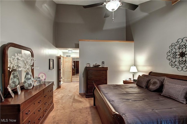 bedroom with light carpet, a towering ceiling, and ceiling fan