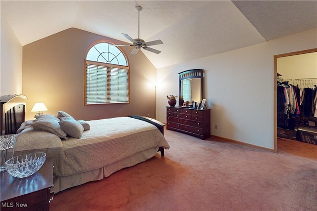 carpeted bedroom featuring ceiling fan, a spacious closet, vaulted ceiling, and a closet