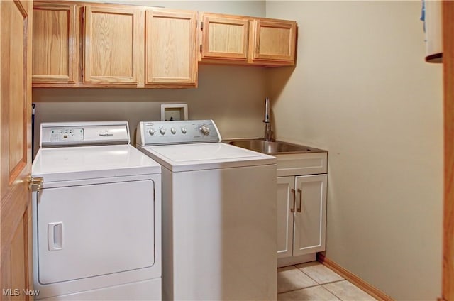 laundry room featuring cabinets, separate washer and dryer, sink, and light tile patterned floors