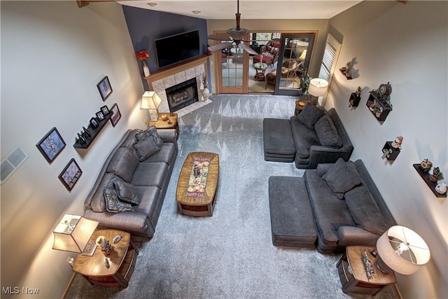 carpeted living room with a fireplace and ceiling fan