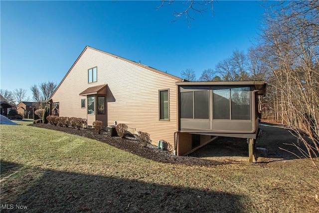 view of property exterior featuring a lawn and a sunroom