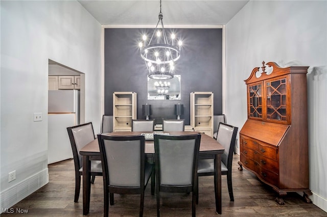 dining space featuring dark hardwood / wood-style floors and a chandelier