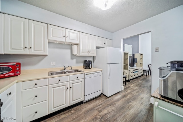 kitchen featuring white cabinetry, sink, dark hardwood / wood-style flooring, white appliances, and a textured ceiling