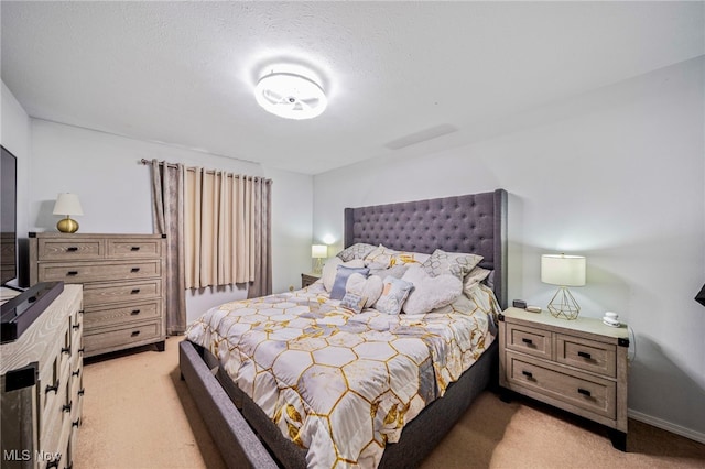 bedroom with light colored carpet and a textured ceiling