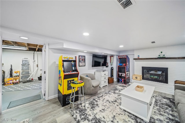 living room featuring light hardwood / wood-style floors and a brick fireplace