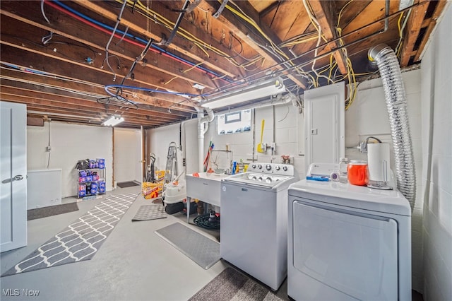 washroom with sink, electric panel, and washing machine and dryer