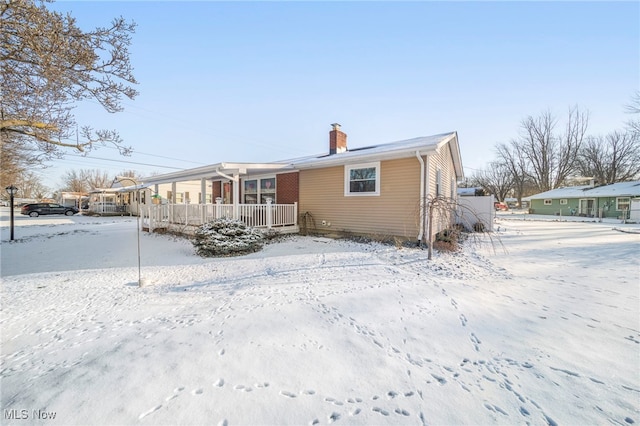 snow covered property featuring a porch