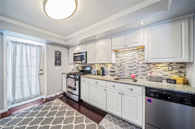 kitchen with appliances with stainless steel finishes, dark hardwood / wood-style floors, sink, and white cabinets