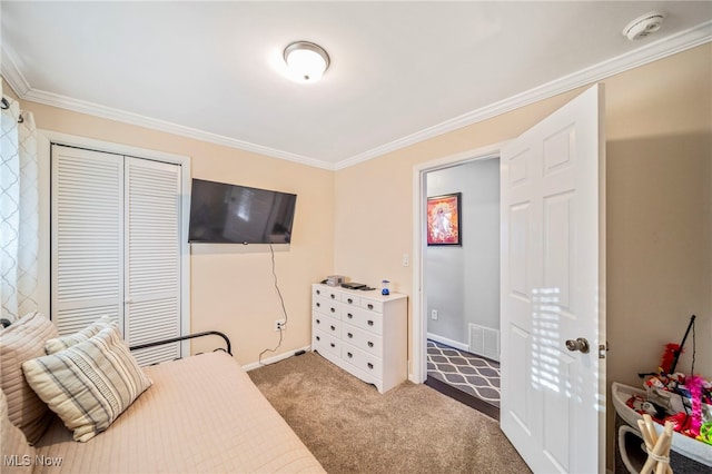 bedroom featuring crown molding, carpet floors, and a closet