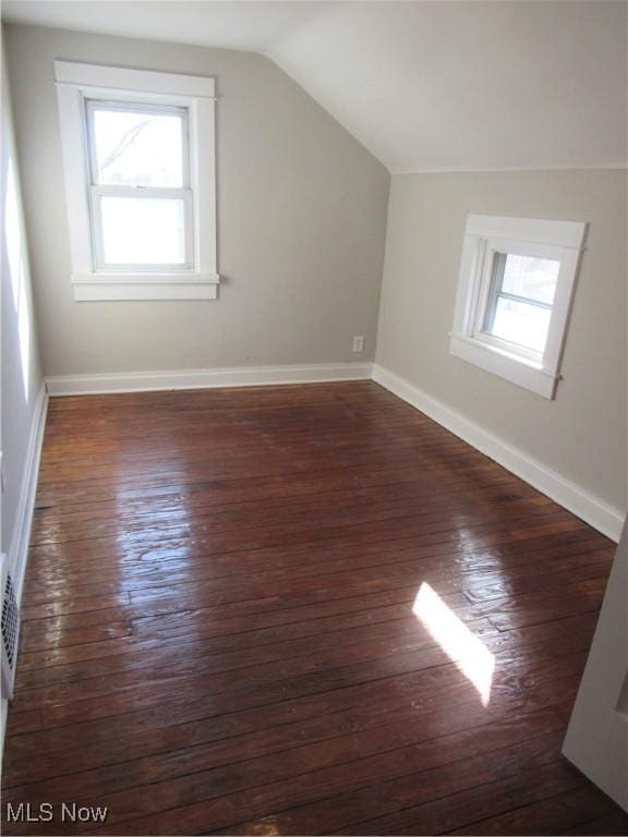 additional living space with lofted ceiling, dark wood-type flooring, and a wealth of natural light