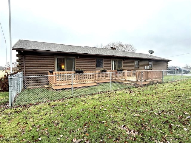 rear view of property featuring a wooden deck and a lawn