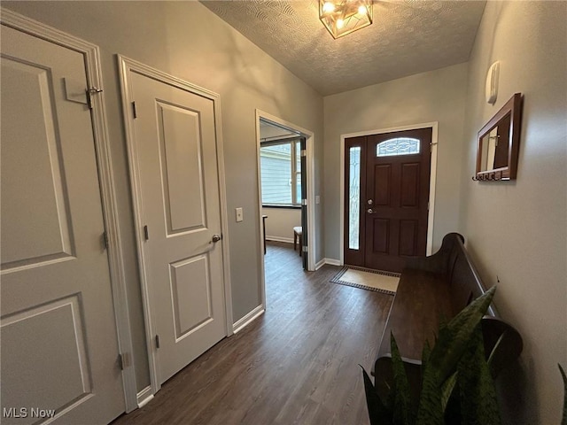 foyer entrance featuring a textured ceiling and dark hardwood / wood-style flooring