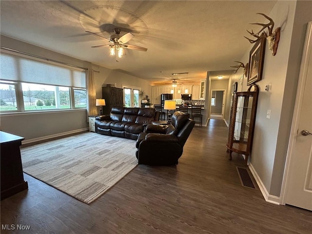 living room with dark hardwood / wood-style floors and ceiling fan