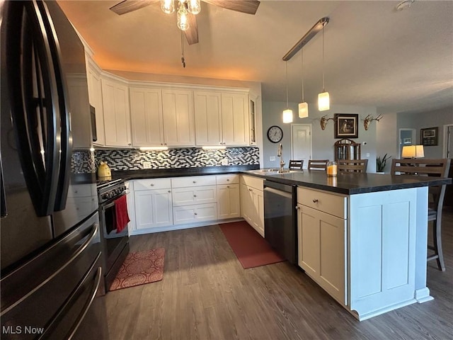 kitchen with dishwasher, black fridge, white cabinets, and a kitchen bar