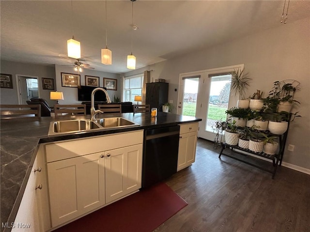 kitchen featuring sink, white cabinetry, black dishwasher, a healthy amount of sunlight, and decorative light fixtures