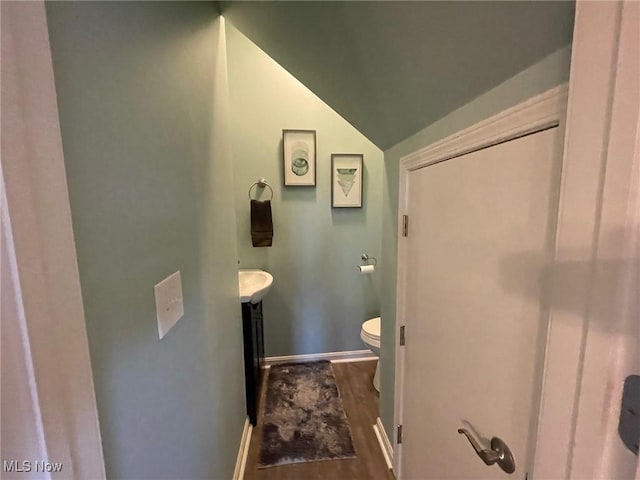 bathroom with vanity, lofted ceiling, hardwood / wood-style floors, and toilet