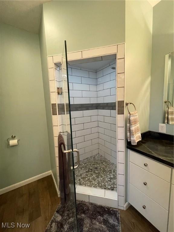 bathroom featuring hardwood / wood-style flooring, vanity, and a shower with door