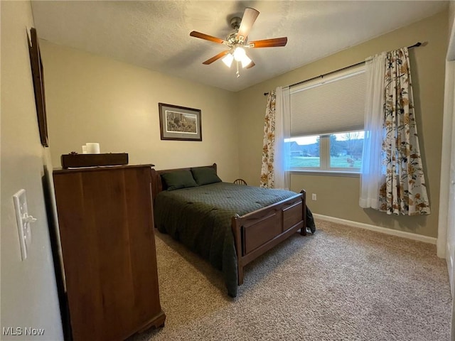 bedroom featuring light carpet, a textured ceiling, and ceiling fan