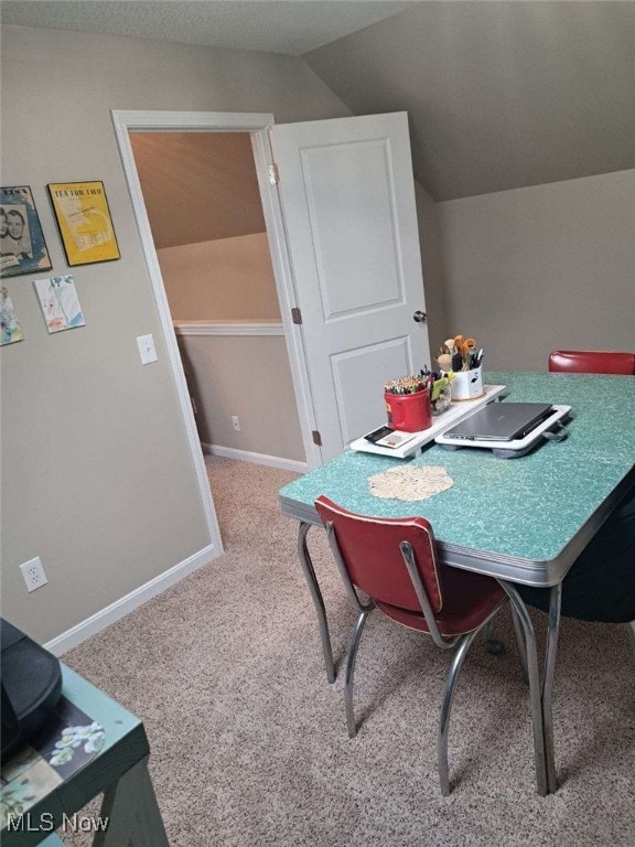 dining room featuring vaulted ceiling and carpet flooring