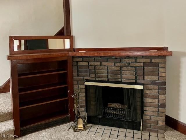 details with a brick fireplace and carpet