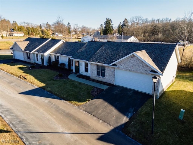 ranch-style house with a garage and a front lawn