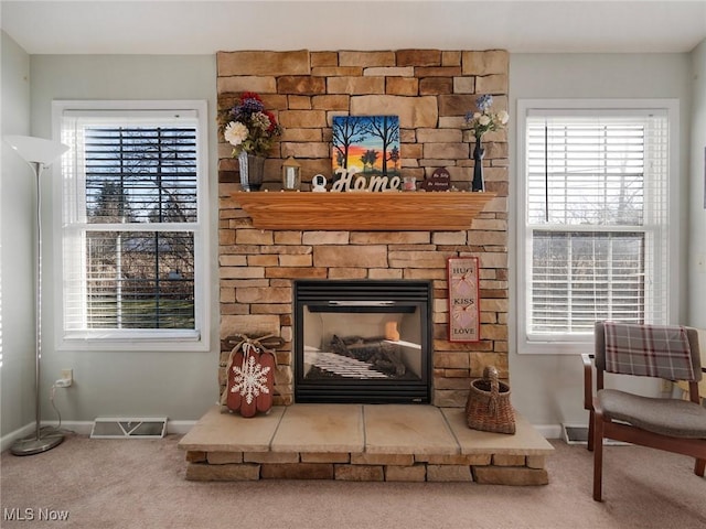 interior details with a stone fireplace and carpet floors