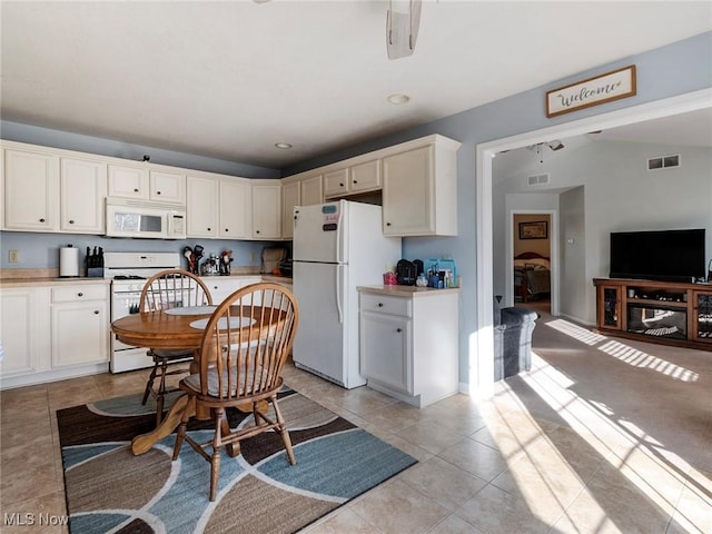 kitchen featuring light tile patterned flooring, white cabinets, and white appliances