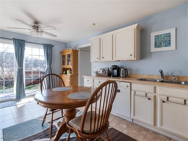 tiled dining area featuring ceiling fan and sink