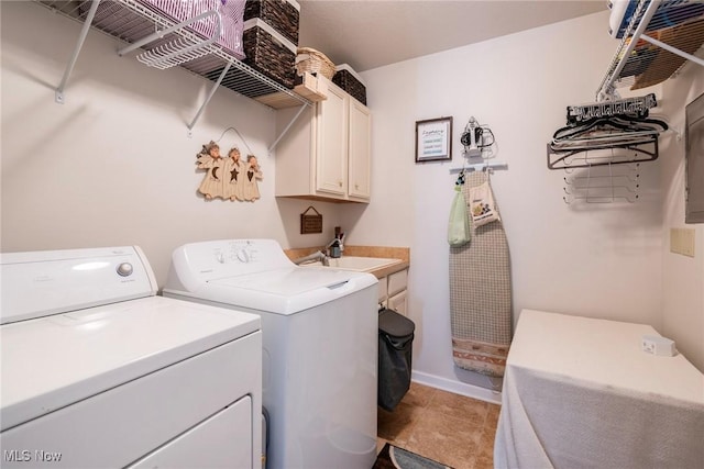 clothes washing area with independent washer and dryer, cabinets, sink, and light tile patterned floors