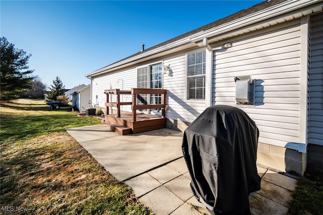 back of house featuring central AC unit, a yard, and a patio area