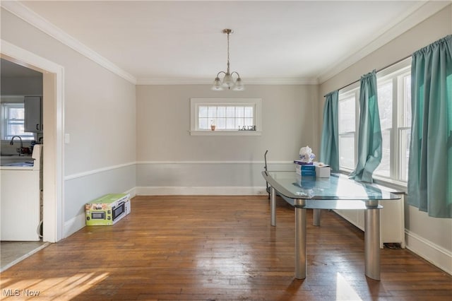 dining area featuring sink, a wealth of natural light, ornamental molding, and dark hardwood / wood-style floors