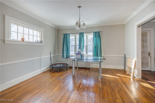 dining space featuring an inviting chandelier, hardwood / wood-style floors, crown molding, and radiator heating unit