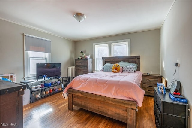 bedroom featuring ornamental molding, radiator, and hardwood / wood-style floors