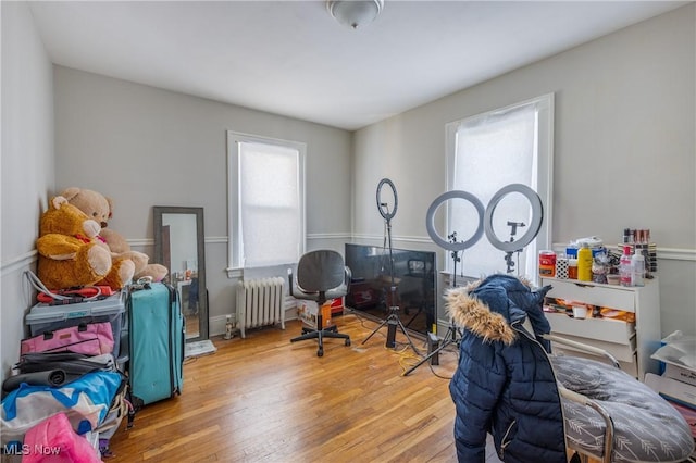 bedroom with radiator heating unit and wood-type flooring