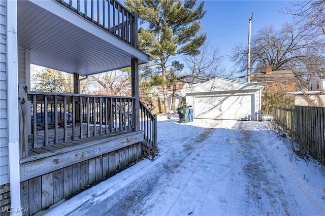 snow covered deck featuring a garage and an outdoor structure