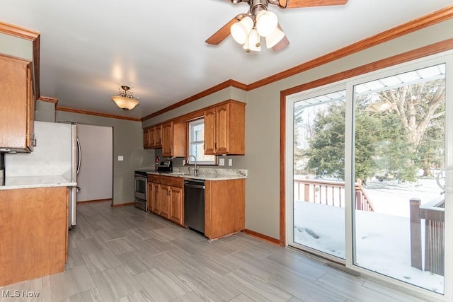 kitchen featuring crown molding, appliances with stainless steel finishes, sink, and ceiling fan