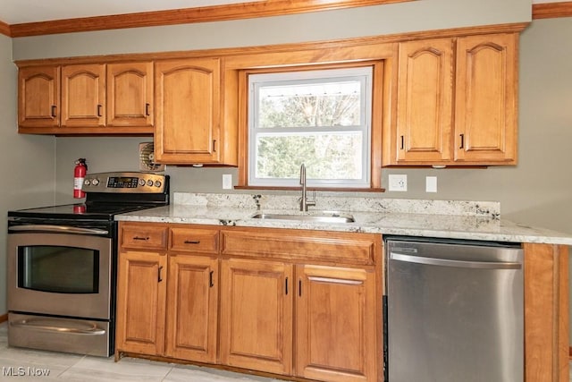 kitchen with light stone counters, sink, ornamental molding, and appliances with stainless steel finishes