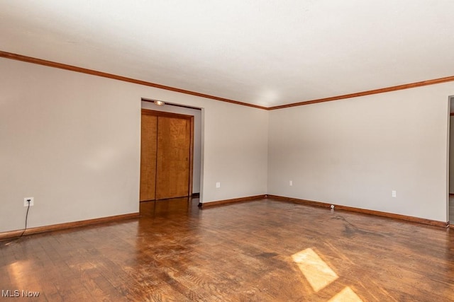 empty room with wood-type flooring and crown molding