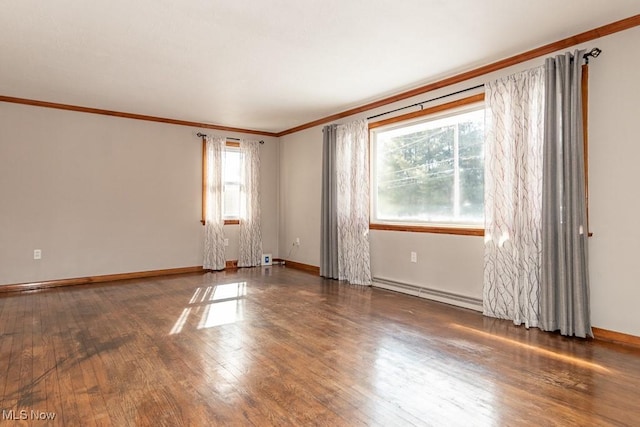 empty room with ornamental molding, dark hardwood / wood-style flooring, and a baseboard heating unit