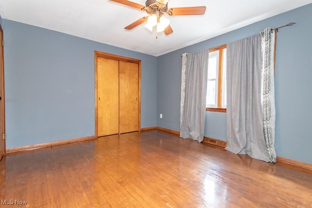 unfurnished bedroom with hardwood / wood-style flooring, a closet, and ceiling fan