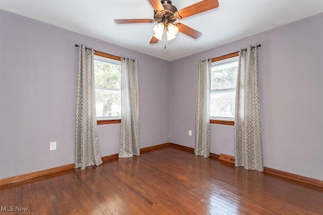 unfurnished room with ceiling fan, dark wood-type flooring, and a healthy amount of sunlight