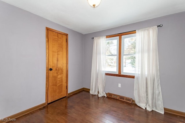 spare room featuring dark hardwood / wood-style flooring